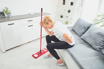 Female with back pain after dusting floor